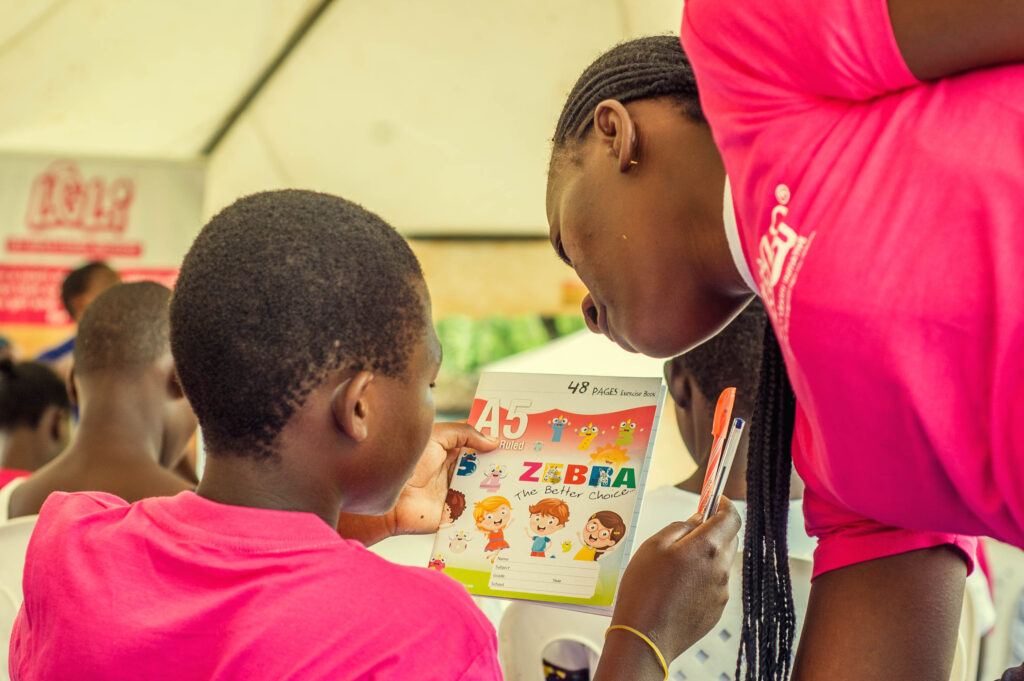 LGLI girls having a look at a book and pens received